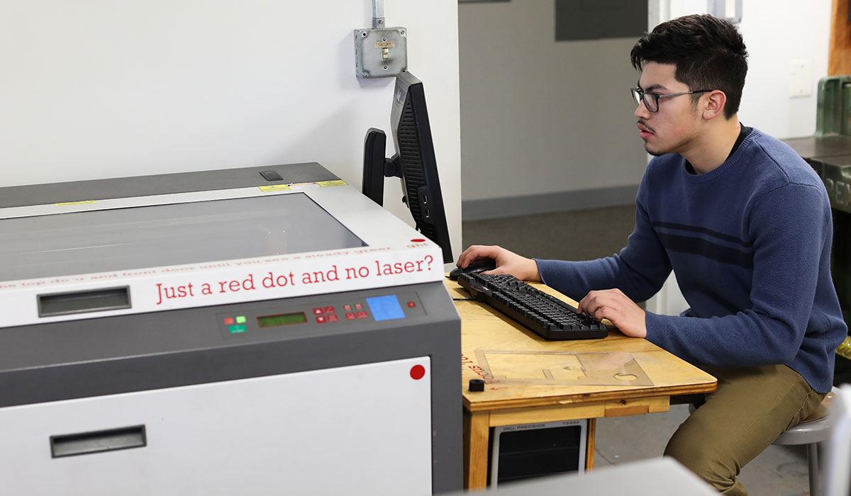 Student working with laser cut machine