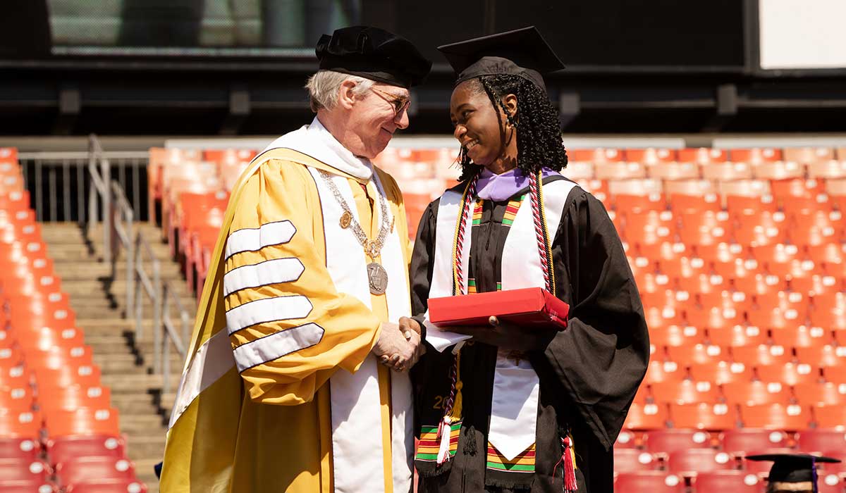 president harvey and schola eburuoh shake hands in commencement cerimony